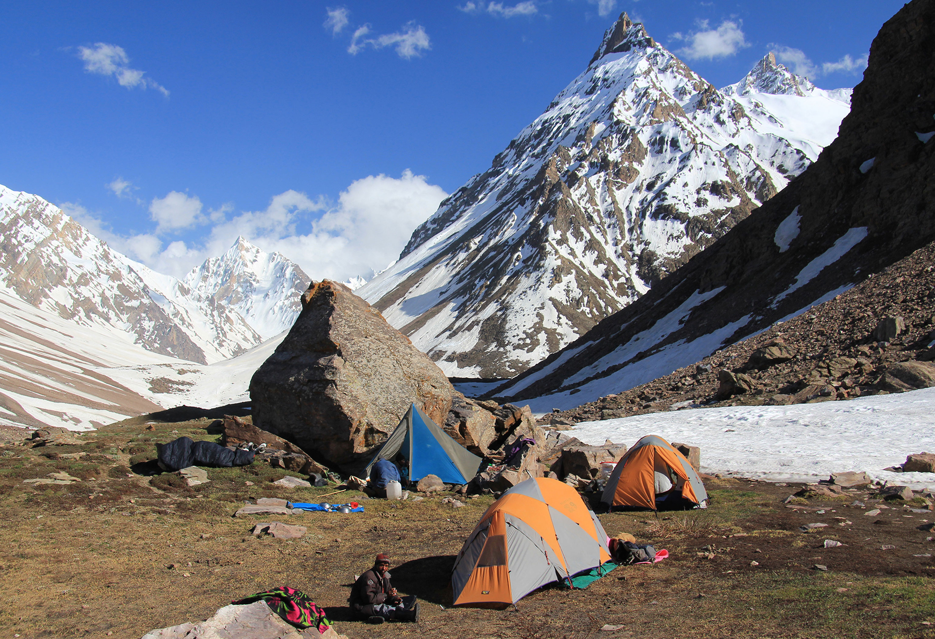Long-distance hiking Great Himalaya Trail Camp with tents imposing mountains