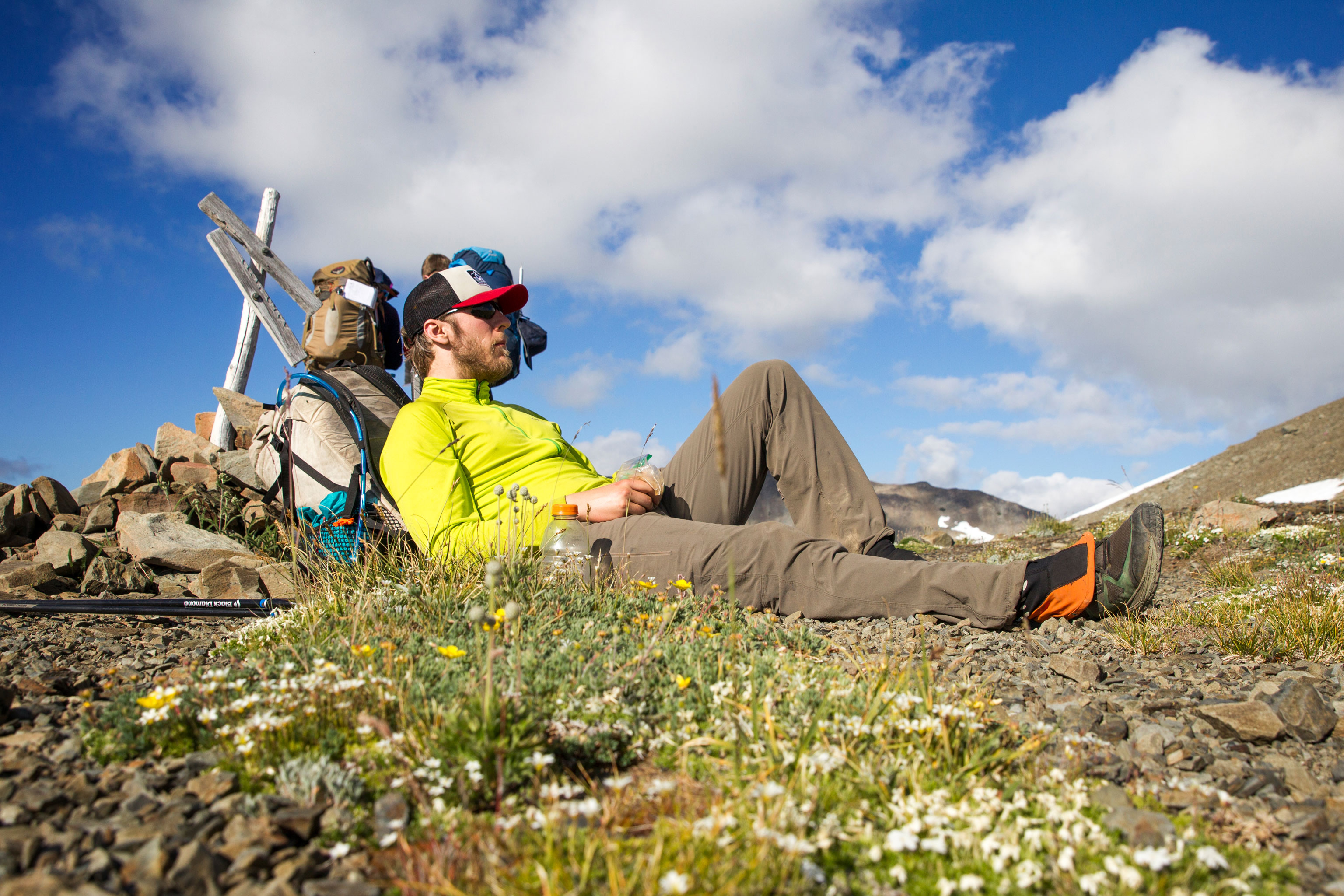 An exhausted thru-hiker sits on the ground