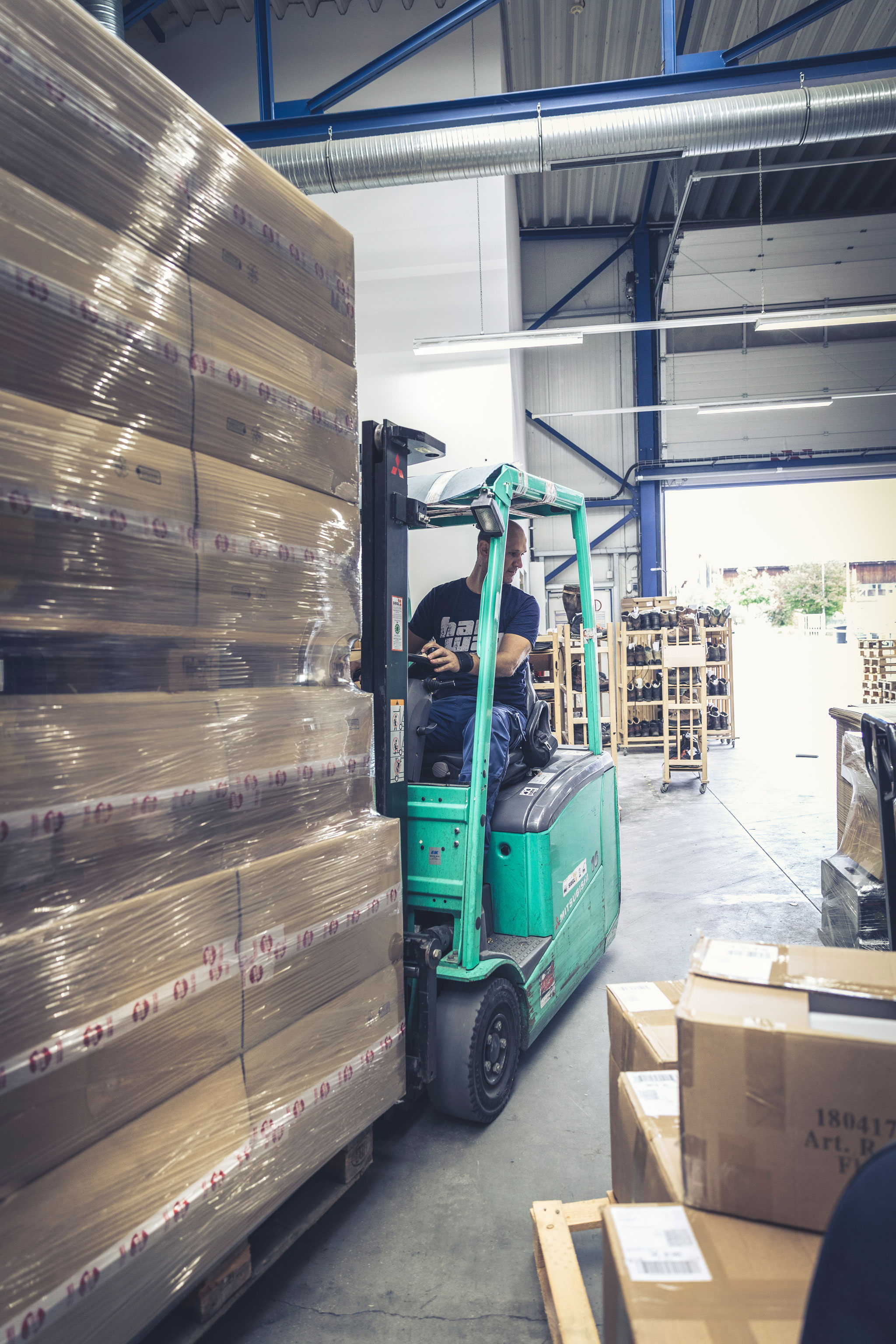 Hanwag employee Mario, driving the forklift truck in the warehouse. Best walking boots