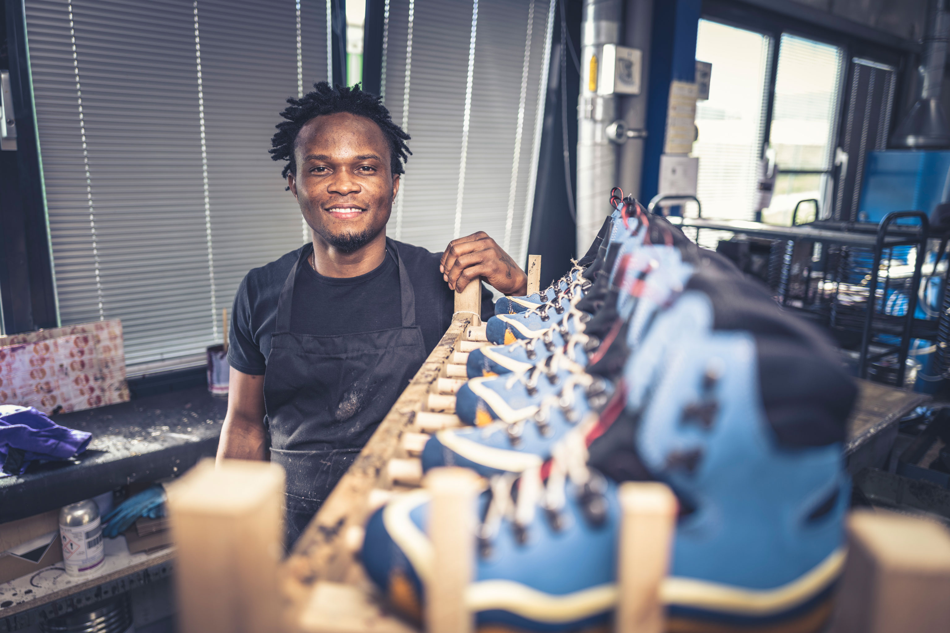 Hanwag employee Steven by a shelf full of blue boot uppers. German boot manufacturers