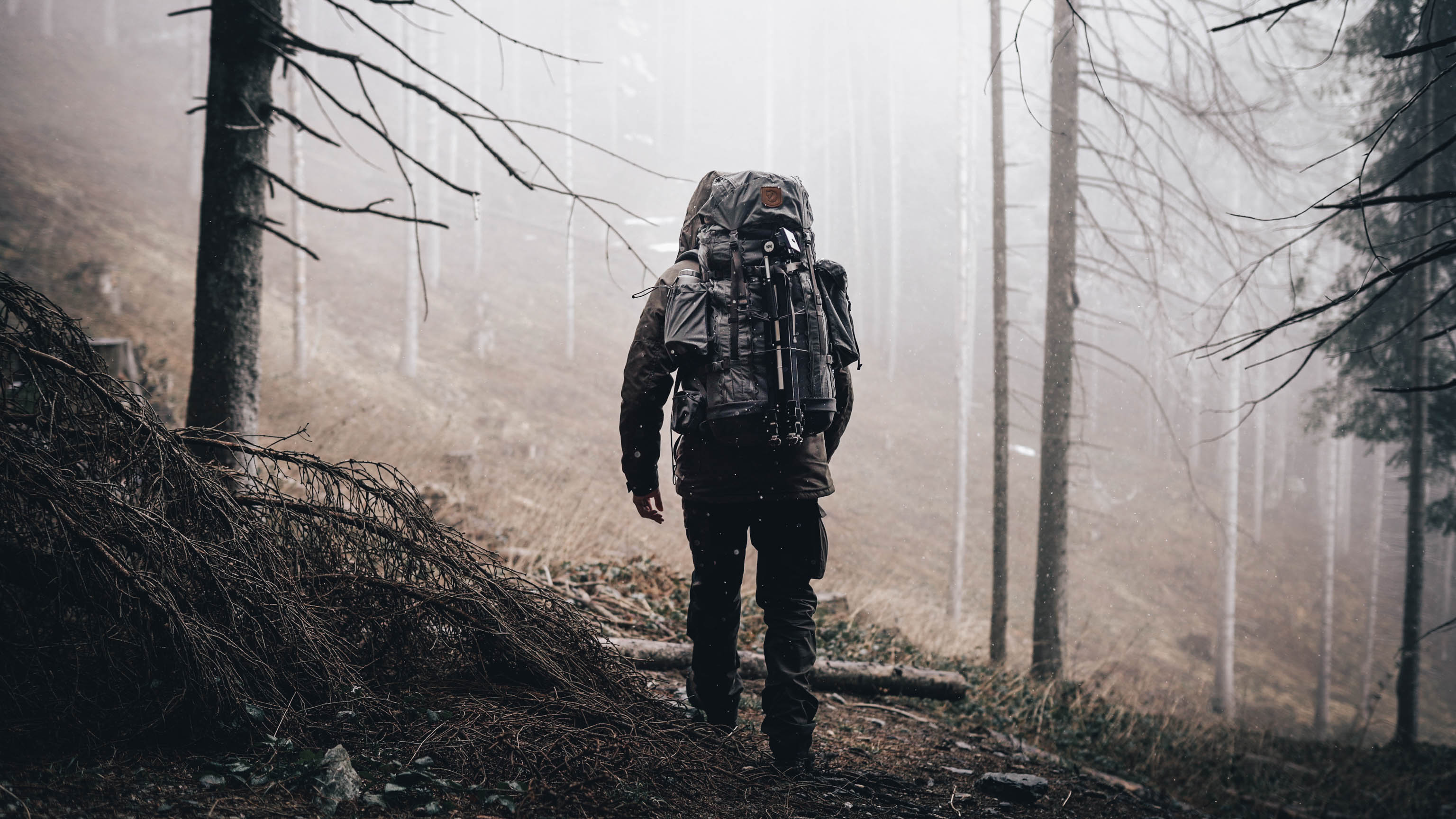 Alex Wander mit vollgepackten Rucksack und Überlebensausrüestung in Bergwald