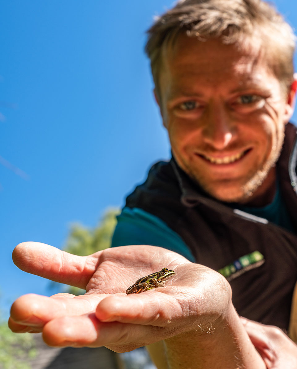 Nature guide Lukas Rinnhofer with a small frog in his hand
