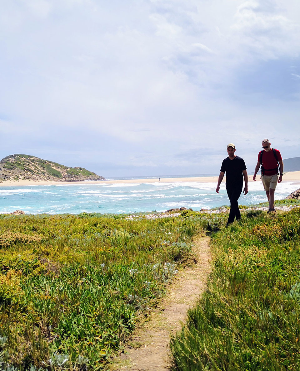 Two men Coastal walks with a sandy beach in the background