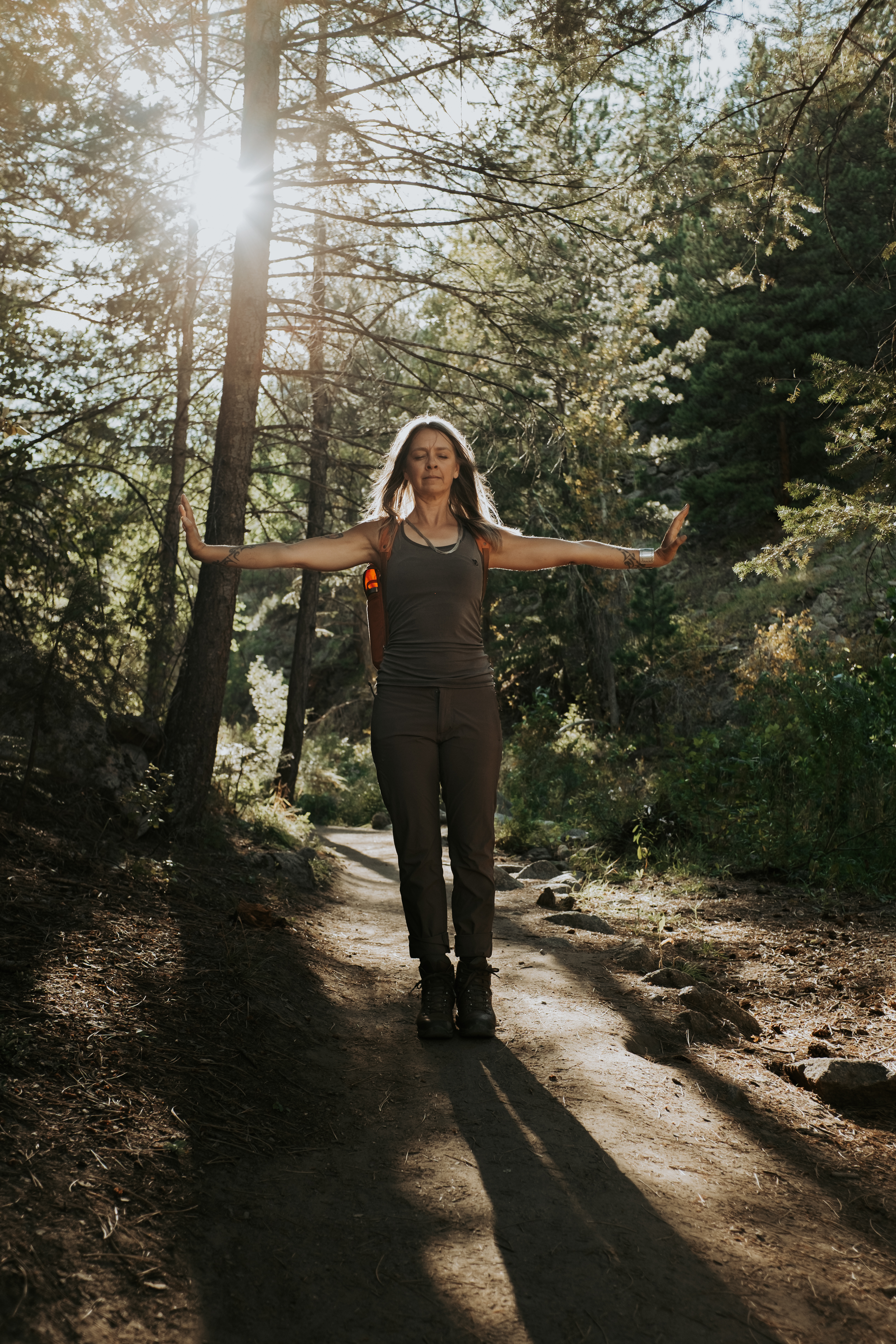 Jenny Bertram in a Qigong pose on a forest path