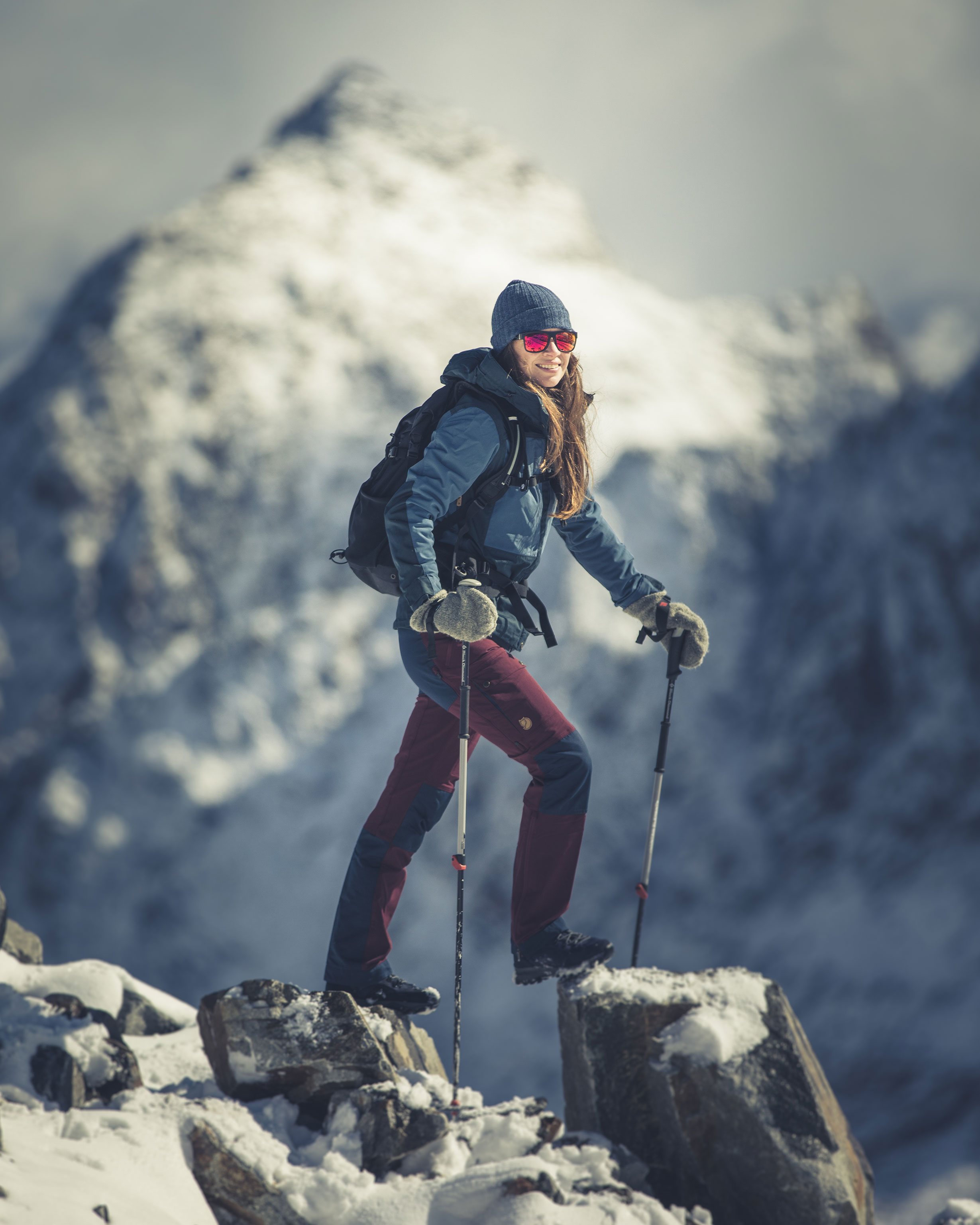 Cold feet causes A woman stands on a rock in wintery alpine terrain