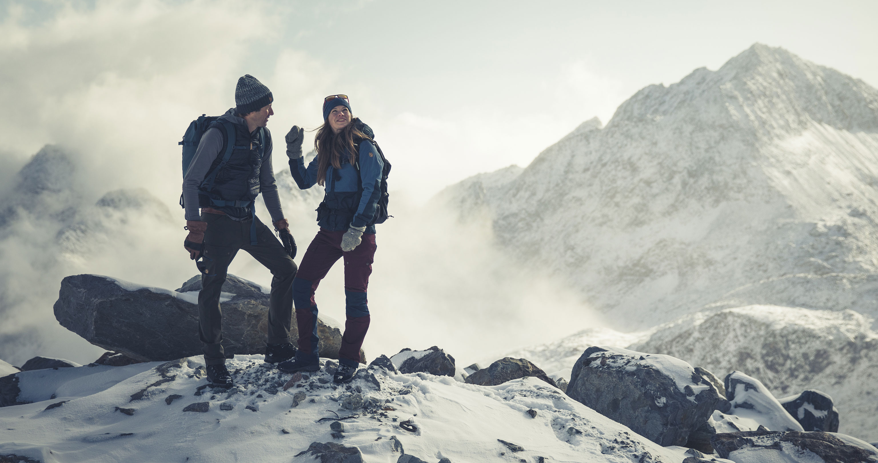 A couple wearing warm walking shoes from Hanwag in snowy mountain terrain