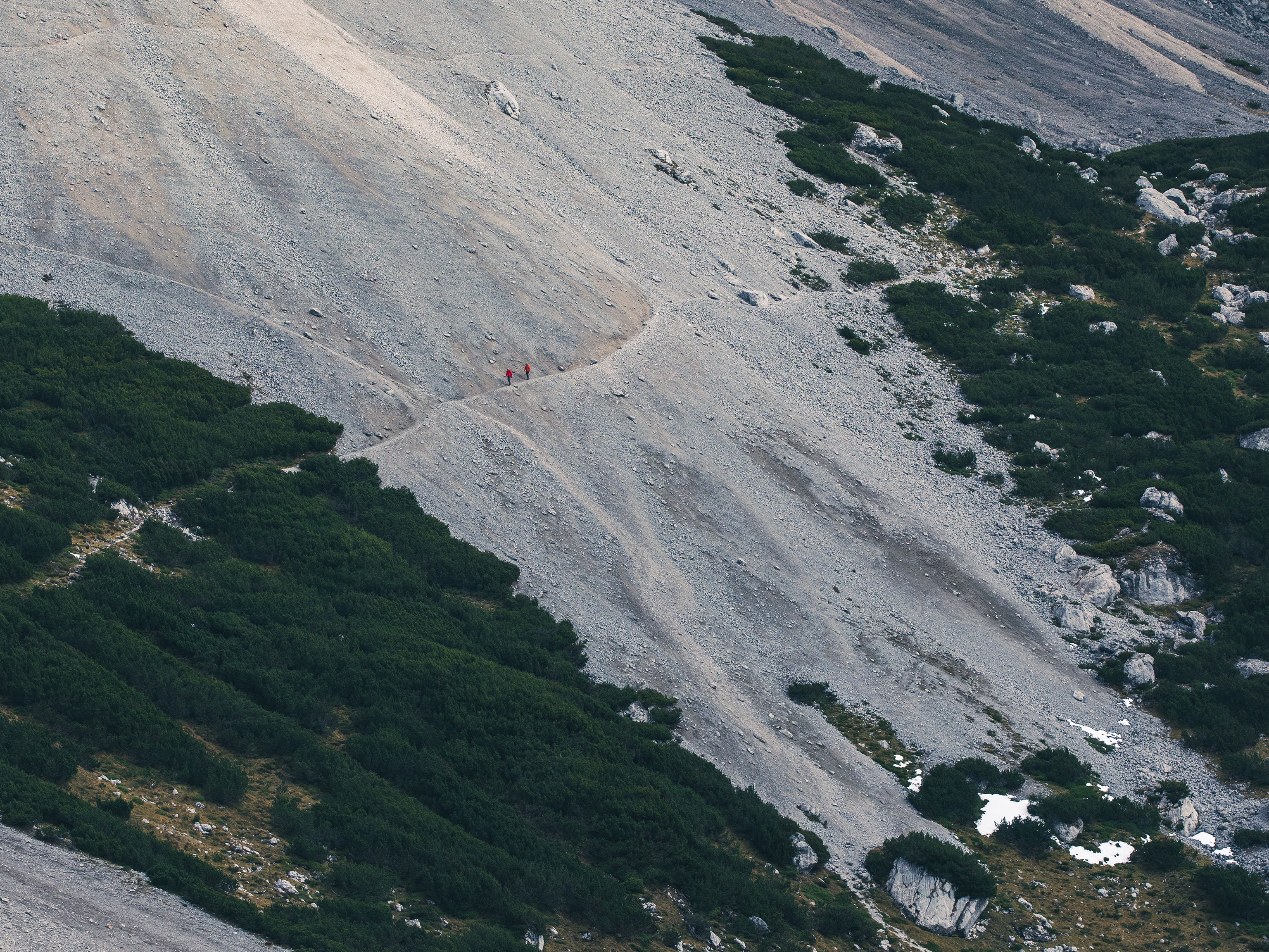 Zwei Bergsteiger gehen über einen Pfad in den Alpen