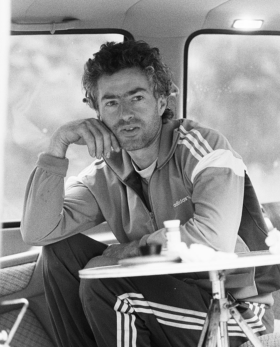 Sepp Gschwendtner sitzt im Trainingsanzug im Campingbus während einer Kletterpause