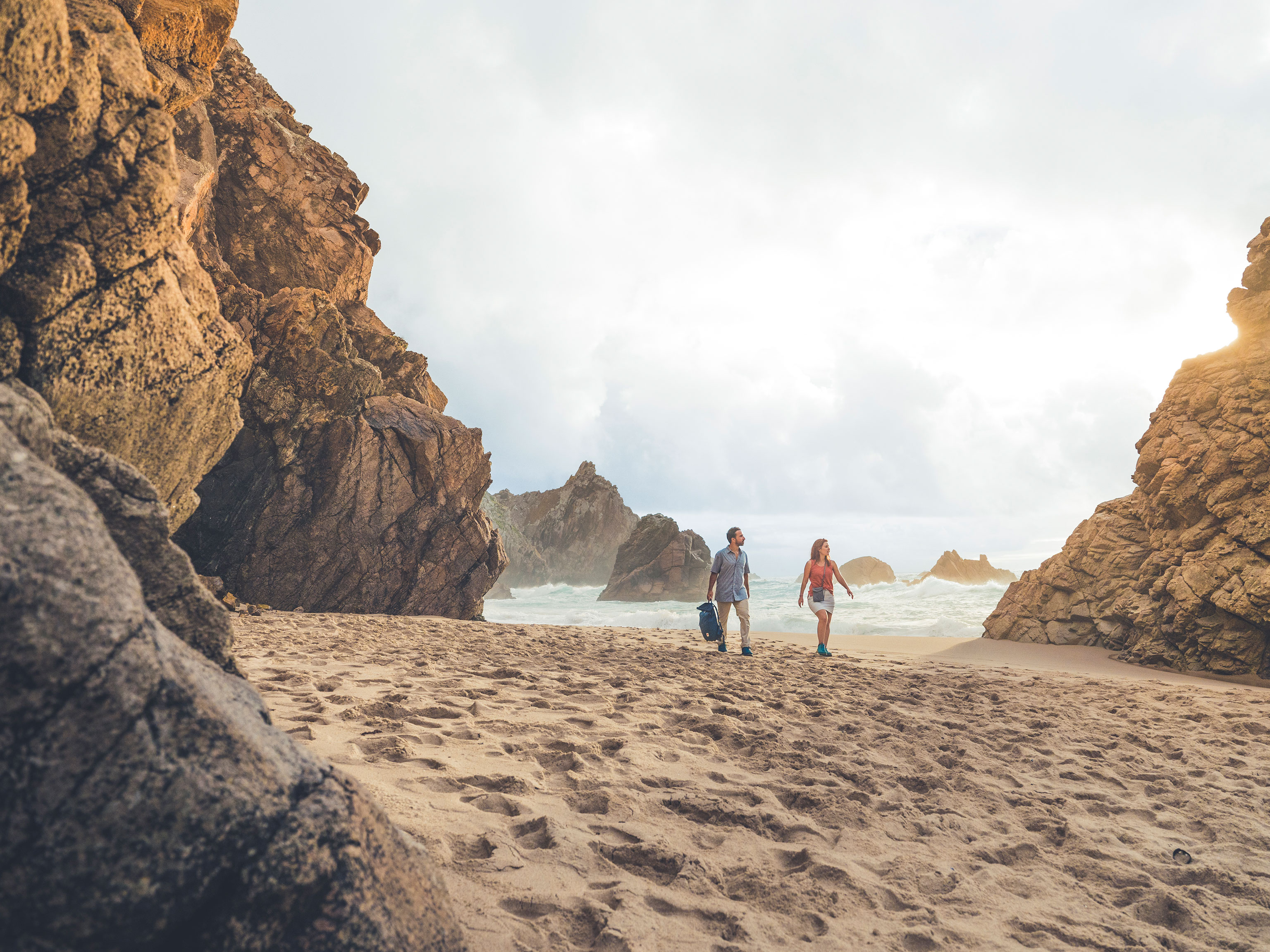 Zwei Wanderer am Strand von Almocageme bei Sintra in Portugal