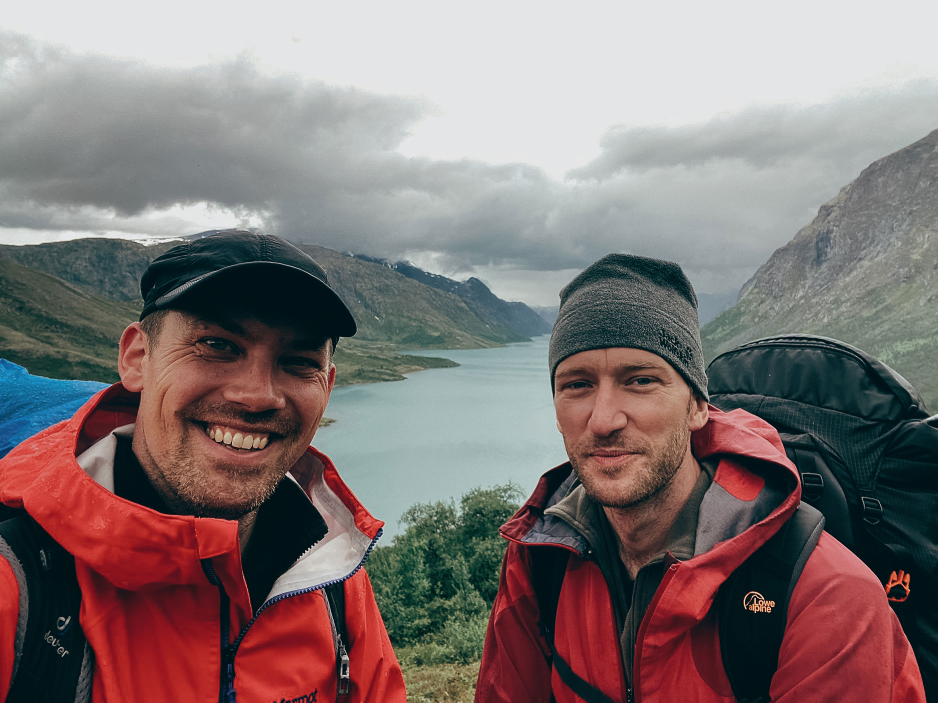 Two men on a Jotunheimen hike standing in front of a lake