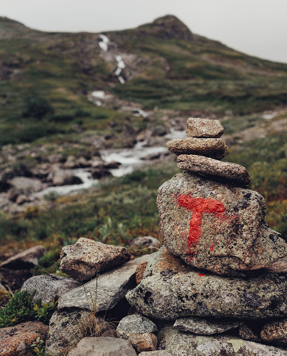 Ein rotes T auf einem Stein als Wegmarkierung beim Wandern im Jotunheimen Nationalpark in Norwegen