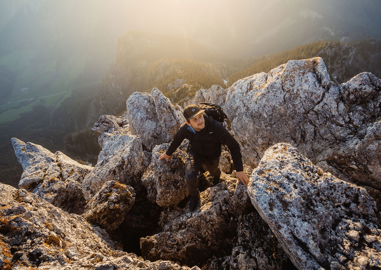 A close-up of a mountaineer climbing up a rocky ridge