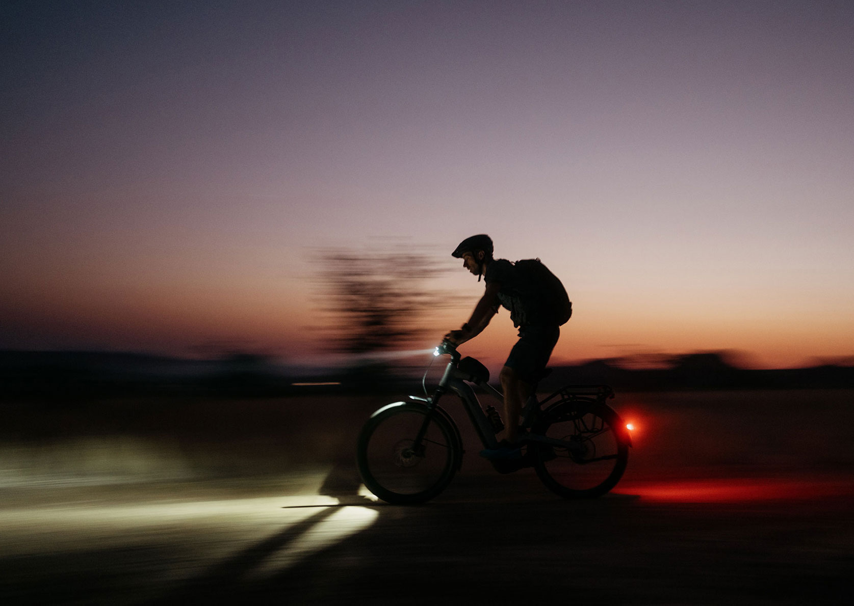 Mitzieher-Bild eines Fahrradfahrers bei Dunkelheit
