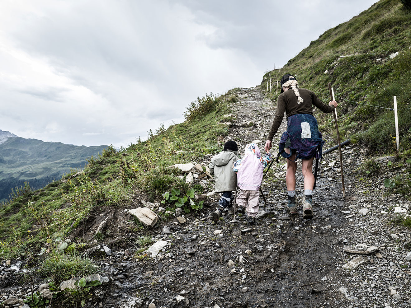 Katharina guides her two small children up a mountain path